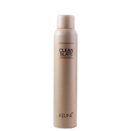 A imagem mostra o shampoo a seco Clean Slate da marca Keune. Frasco cilíndrico na cor bege claro com o texto "CLEAN SLATE" em letras maiúsculas pretas, descrevendo um "shampoo refrescante purificante" abaixo. O logotipo Keune aparece na parte inferior