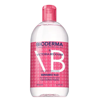 Frasco de 500 ml de água micelar Sensibio H2O da Bioderma, em edição limitada com design exclusivo da Victoria Beckham, com predominância de cores rosa e branca.