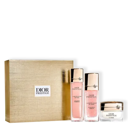 Conjunto de produtos de beleza da marca Dior Prestige, incluindo uma loção, um sérum ativado e um creme em embalagens com detalhes em dourado e rosa. A caixa de presente em tom bege completa o conjunto.