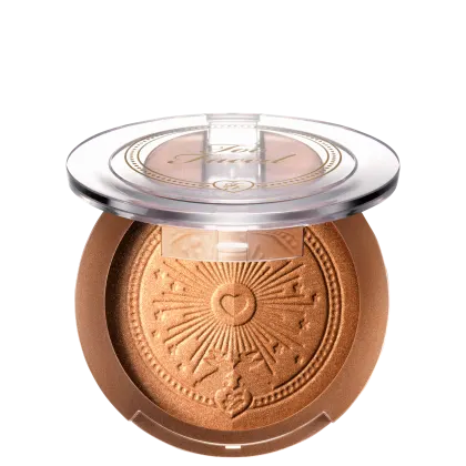 Pó bronzeador compacto em embalagem redonda de plástico transparente, com detalhes dourados e um desenho de sol estampado no centro. O produto possui uma tonalidade dourada brilhante.