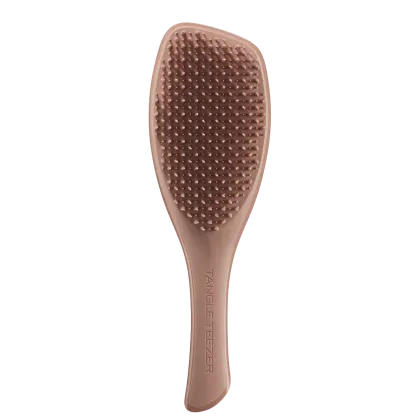 Escova de cabelo Tangle Teezer de cor rosa clara, com superfície pontiaguda e texturizada, com o nome da marca impresso na lateral.