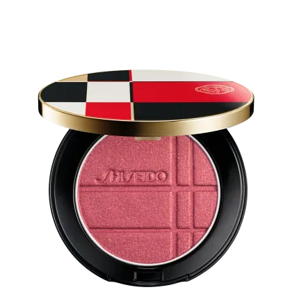 Pó Shiseido Color + Glow Enhancer  em embalagem redonda preta e dourada, com design xadrez em vermelho, branco e preto. O produto apresenta textura aveludada e logotipo da marca.