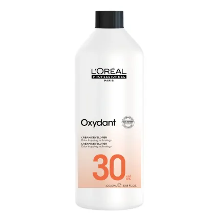 Frasco branco da linha Oxydant da L'Oréal Professionnel, com rótulo preto e laranja, contendo 1000ml de creme revelador com tecnologia de bloqueio de odor, com concentração de 30 volumes.