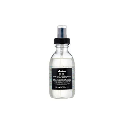 Frasco de vidro transparente com spray preto contendo óleo de beleza Davines Oi Oil. Rótulo preto com texto branco indicando o nome do produto e informações sobre seu uso em diferentes tipos de cabelo.