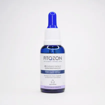 Frasco de vidro azul com tampa branca contendo produto de cuidados faciais da marca Grandha, com rótulo indicando tratar-se de um tratamento dermorregenerador com óleos vegetais e essências ozonizadas.