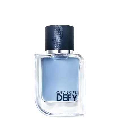 O frasco é de vidro transparente, com um design elegante e moderno. O rótulo exibe o nome da fragrância em letras azuis escuras contra um fundo claro. A tampa do frasco é de cor azul escura, com um acabamento texturizado.