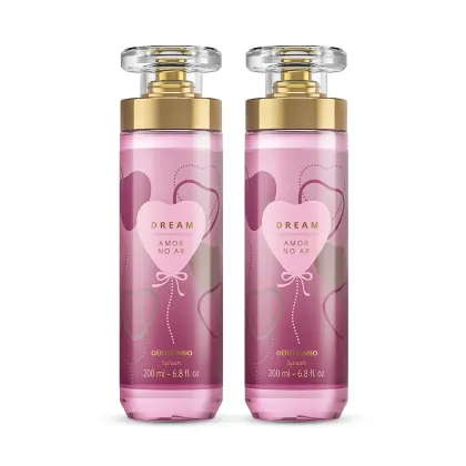 Imagem de dois frascos de body splash da linha Dream Amor no Ar. A embalagem é de vidro, com tampa transparente e válvula spray dourada. O rótulo traz um coração estampado e detalhes em tons de roxo. Cada recipiente traz 200ml do produto.