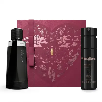 Caixa de presente de cor vinho com um grande coração contendo ilustrações em relevo de temática celestial. Ao lado, dois itens de perfumaria Malbec Black, sendo um frasco de vidro preto com detalhe prata de fragrância e um frasco de body spray preto.