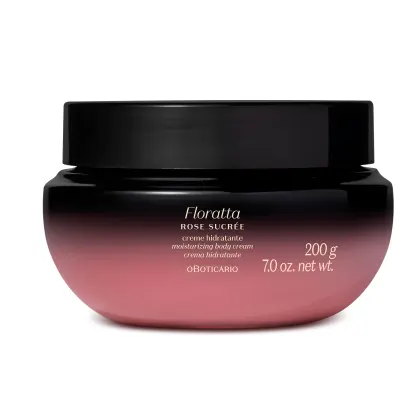 A imagem mostra um pote de creme hidratante corporal da marca Floratta Rose Sucrée. Ele possui um degradê que vai do preto para o roxo, tampa preta e rótulo com informações sobre o produto impresso em letras douradas.