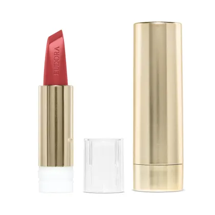 Na imagem o Batom Eudora Glam Amulips na cor Alaranjado Destemido, um tom de alaranjado terroso. O batom está aberto, revelando seu interior com o nome Eudora gravado no produto. A embalagem dourada transmite a elegância e qualidade do produto.