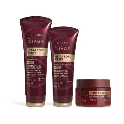 Produtos da linha Siage da Eudora, incluindo shampoo, condicionador e máscara capilar Ultra Bond Reset, em embalagens de plástico com predominância de cores vermelho e dourado.
