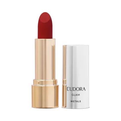 Batom cremoso de cor vermelho intenso em embalagem dourada cilíndrica.  Ao lado, está a tampa na cor prata com o nome do produto "Eudora Glam Metals" impresso. Produto de maquiagem para lábios com acabamento metálico da linha Glam da marca Eudora.
