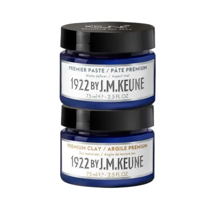 Dois frascos de produtos Keune, um de "Premier Paste" e outro de "Premium Clay", ambos com 75 ml e rótulos azuis com texto em branco.