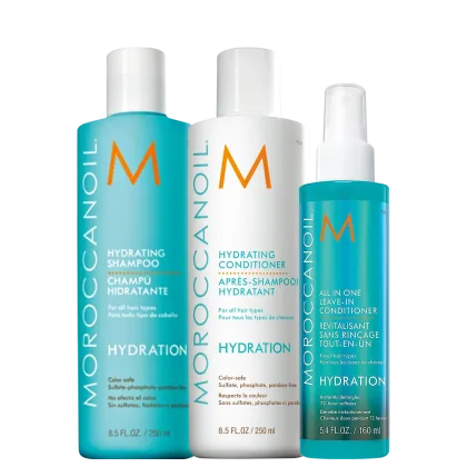 A imagem mostra três produtos da marca Moroccanoil. São um shampoo hidratante, um condicionador hidratante e um leave-in condicionador "All in One", todos em embalagens plásticas cilíndricas. Cores predominantes são turquesa, branco e laranja.