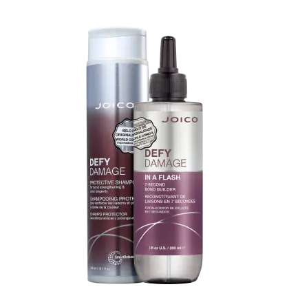 Produtos Joico Defy Damage: shampoo protetor em embalagem prateada e branca, e tratamento de reconstrução em frasco com rótulo roxo e branco, ambos com informações sobre fortalecimento e proteção da cor.