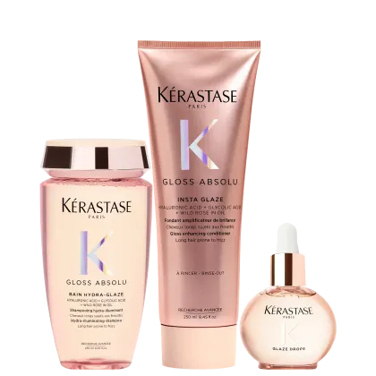 Três produtos da marca Kérastase: um frasco rosa de shampoo Gloss Absolu, um tubo rosa de condicionador Insta Glaze e um frasco de vidro com conta-gotas Glaze Drops, todos com design e rótulos da marca.
