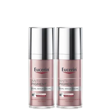 Dois frascos de serum facial Anti-Pigment da marca Eucerin, com embalagem prateada e rosa, apresentando o texto "Anti-Pigment Dual Sérum Facial" e o logotipo da marca.