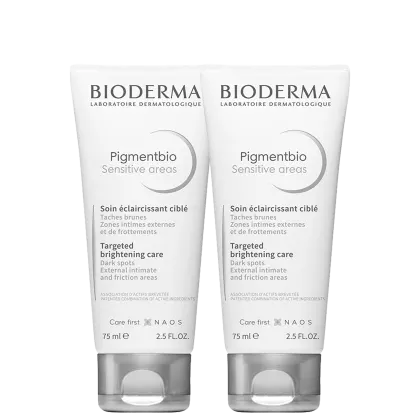 Dois frascos brancos da linha Pigmentbio Sensitive areas da Bioderma, com 75ml cada. Os frascos apresentam rótulos com o nome do produto e informações sobre seu uso para tratar manchas escuras em áreas sensíveis.
