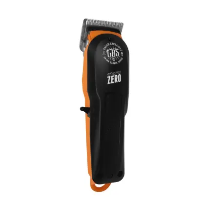 A imagem mostra uma máquina de cortar cabelo com corpo preto com detalhes em laranja. Possui uma lâmina aparadora visível e o logotipo "GBS Salon Exclusive" impresso na parte superior.