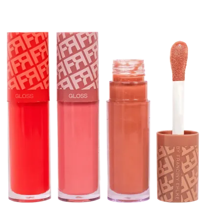 Três tubos de gloss labial da marca Fran by Franciny Ehlke em embalagens vermelhas com padrão gráfico, acompanhados de um frasco de gloss laranja e um aplicador de espuma.