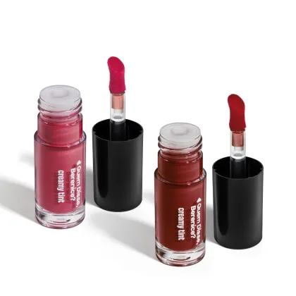 Conjunto de produtos de maquiagem da marca Quem Disse, Berenice? incluindo um batom vermelho em embalagem preta e dois frascos de vidro com líquidos em tons de rosa e marrom.