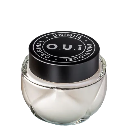 Frasco de vidro transparente com tampa preta redonda contendo produto da marca O.U.i. O rótulo preto destaca o nome da marca e a declaração "Unique Original Indulgent" em letras brancas.