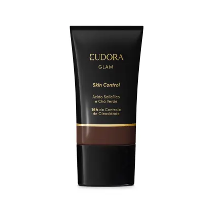 Embalagem plástica preta com detalhes em preto e dourado. Rótulo indica que é um Skin Control com ácido salicílico e chá verde, proporcionando 16 horas de controle da oleosidade. A cor da base é tom marrom escuro.
