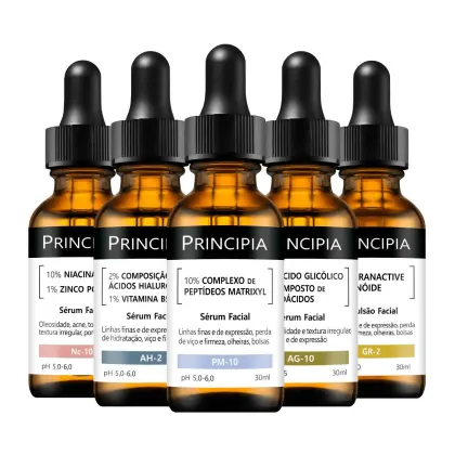 Cinco frascos de sérum facial da marca Principia, com rótulos indicando diferentes formulações e benefícios, como 10% de niacinamida, ácido glicólico e peptídeos matrixyl, em embalagens de vidro âmbar com conta-gotas pretos.