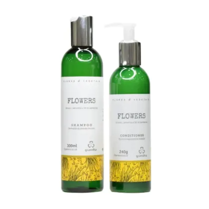 Produtos de beleza da marca Grandha, compostos por um frasco de shampoo e um frasco de condicionador da linha "Flowers", ambos com embalagens verdes e amarelas, contendo informações sobre os produtos impressas nos rótulos.
