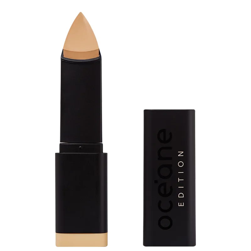 A imagem mostra a Base em Bastão Océane Edition Foundation Stick: embalagem preta com o logotipo "Océane Edition" impresso em relevo na parte frontal. A base tem formato triangular.