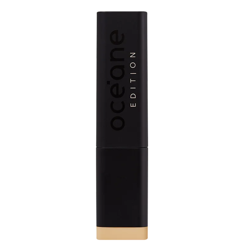 A imagem mostra a embalagem da Base Océane Edition Foundation Stick com formato retangular e cor preta fosca. Destaca a palavra "Océane" em letras maiúsculas pretas e a inscrição "EDITION" abaixo em branco, ambos em relevo na superfície da embalagem.