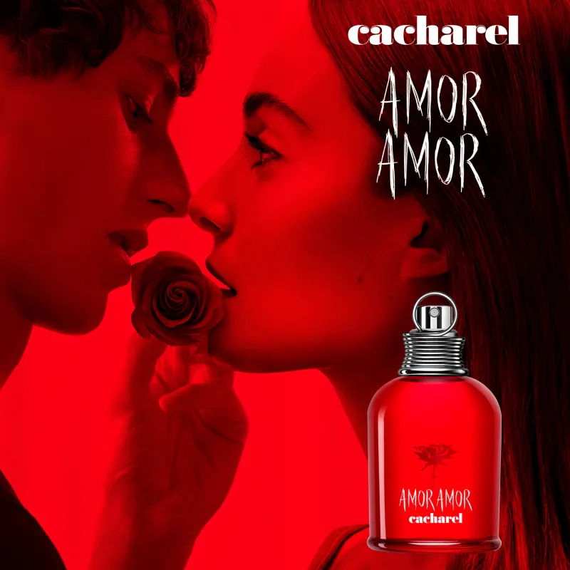Frasco de perfume Amor Amor da Cacharel, com design arredondado e tampa metálica, em vermelho brilhante com logotipo e nome da marca em destaque.