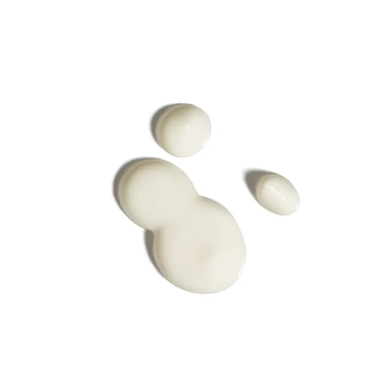 Textura branca e cremosa do protetor solar facial antioxidante FPS 70 Ultra Fluído da marca Boti.Sun, de aparência fluída e brilhante espalhada em superfície branca.