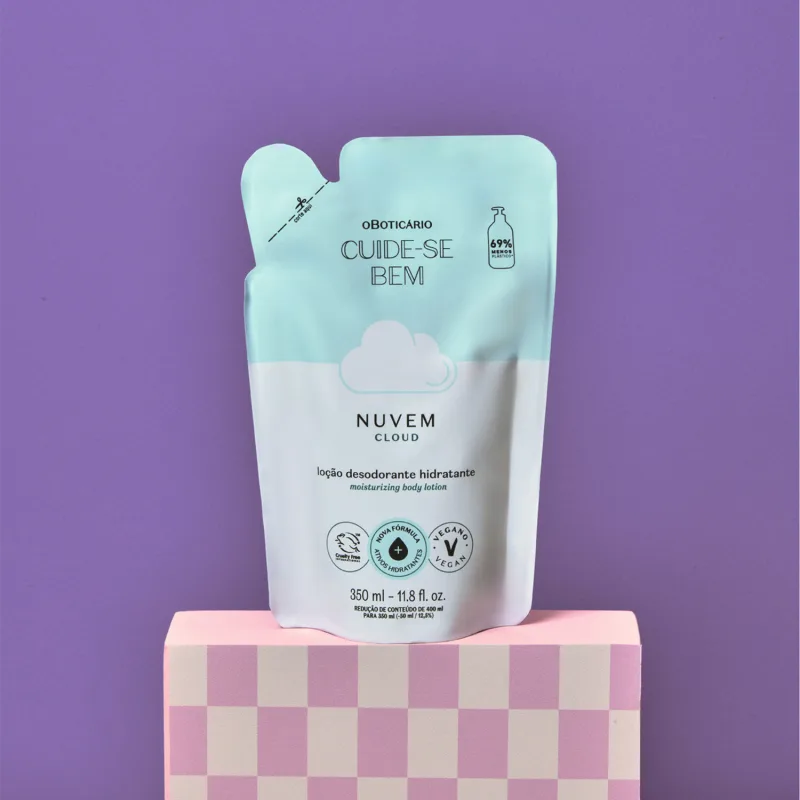 Refil de loção hidratante corporal Cuide-se Bem Nuvem em sachê nas cores azul e branco com nuvem ilustrada em fundo roxo, apoiada sobre superfície rosa com padrão quadriculado.