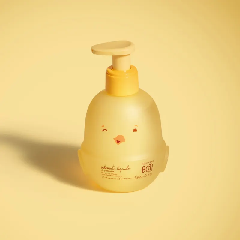 Frasco em forma de passarinho amarelo com detalhes laranjas contendo 200ml de sabonete líquido de glicerina da marca Boti Baby em fundo alaranjado.