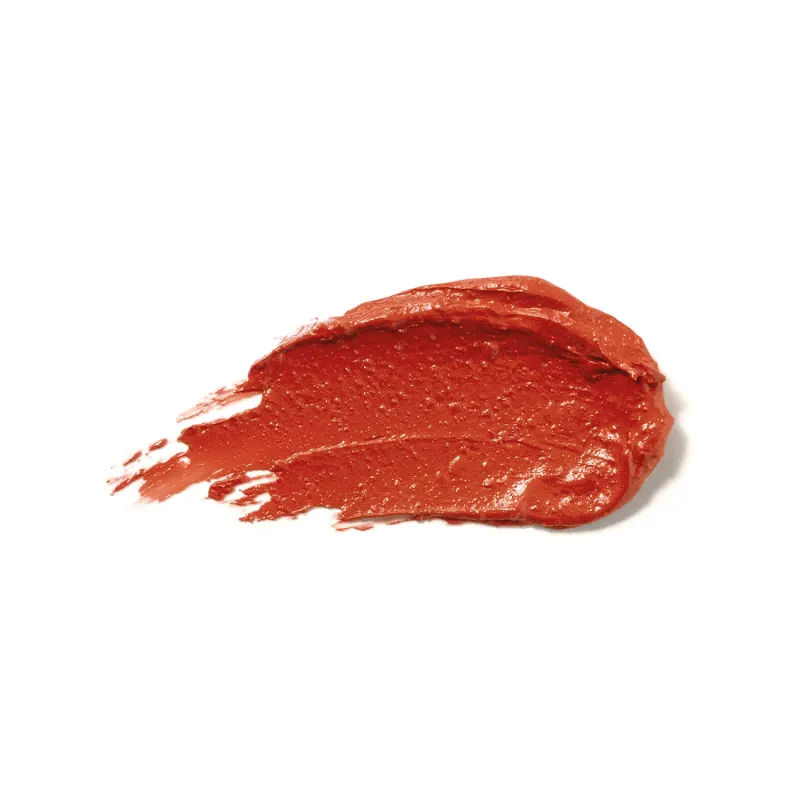 Textura cremosa e brilhante do batom glossy na cor Coral da marca Make B. A aparência é brilhante e leve e está espalhada em superfície branca.
