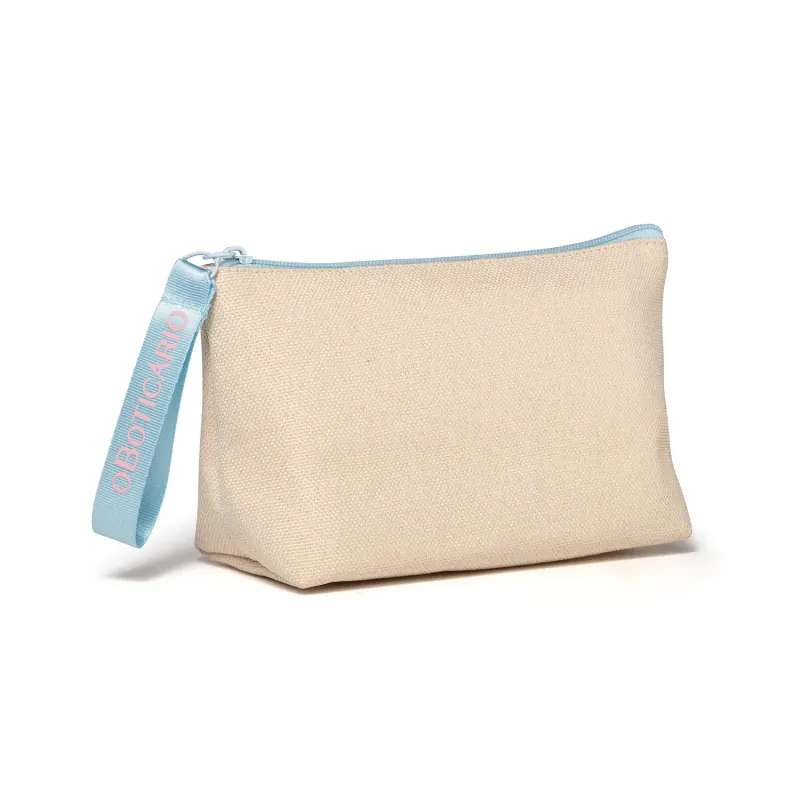 Necessaire de tecido bege com zíper e alça azul, com a marca O Boticário bordado em letras bege.