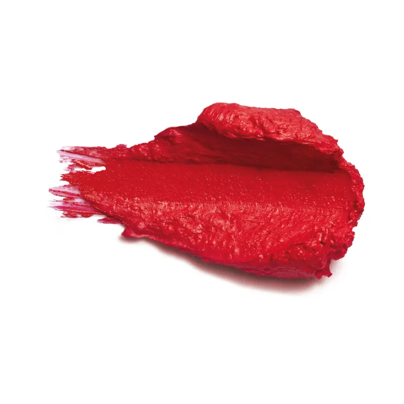 Amostra de batom de cor vermelha intensa. O produto tem uma textura espessa e cremosa, com uma superfície irregular e brilhante. Há vestígios do produto espalhados ao redor. 
