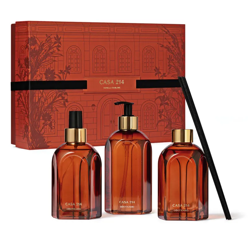 Quatro itens da marca Casa 2'4 Vanilla Sublime em tons de vinho, dourado e preto, sendo uma caixa presenteável com ilustrações e três frascos de vidro sendo um de sabonete líquido, outro de aromatizador de em spray e outro de difusor de ambientes.
