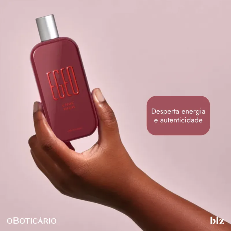 Uma mão feminina segura o frasco em uma posição elevada.