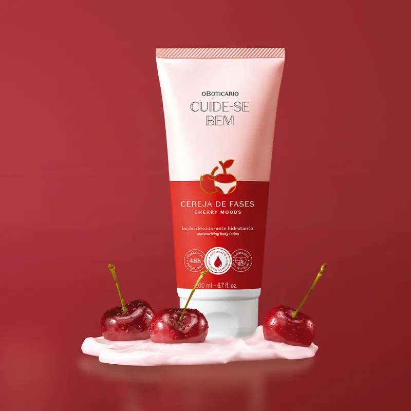 Imagem de frasco de loção corporal hidratante Cuide-se Bem Cereja de Fases, com rótulo rosa e vermelho. O produto possui uma ilustração de uma cereja vermelha e está em um cenário com fundo na cor vinho. Há um creme branco e cerejas frescas na superfície.