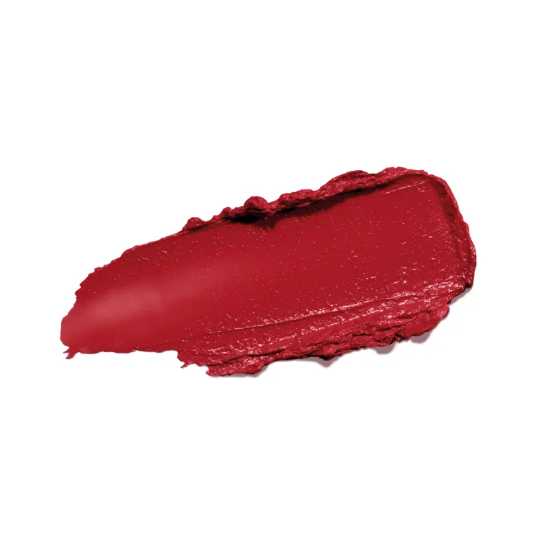 Textura cremosa de tom avermelhado com acabamento aveludado e brilho sutil, espalhada sobre superfície branca, ocupando a maior parte da superfície da imagem.