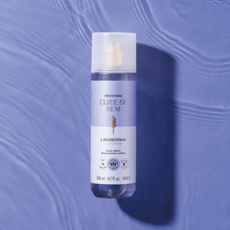 Frasco branco de item de perfumaria da marca Cuide-se bem, com rótulo roxo e dourado, sobre superfície azul com reflexos ondulados.
