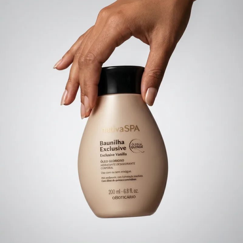 Embalagem de item de cuidados para corpo e banho da marca Nativa SPA Baunilha Exclusive sendo seguro por mão feminina de pele branca em fundo cinza claro.