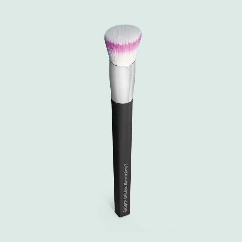 Pincel para maquiagem Duo Fiber Super Funcional da marca Quem Disse, Berenice? com cabo preto e prateado e cerdas macias nas cores ranca e bege. O acessório está em fundo azul claro.