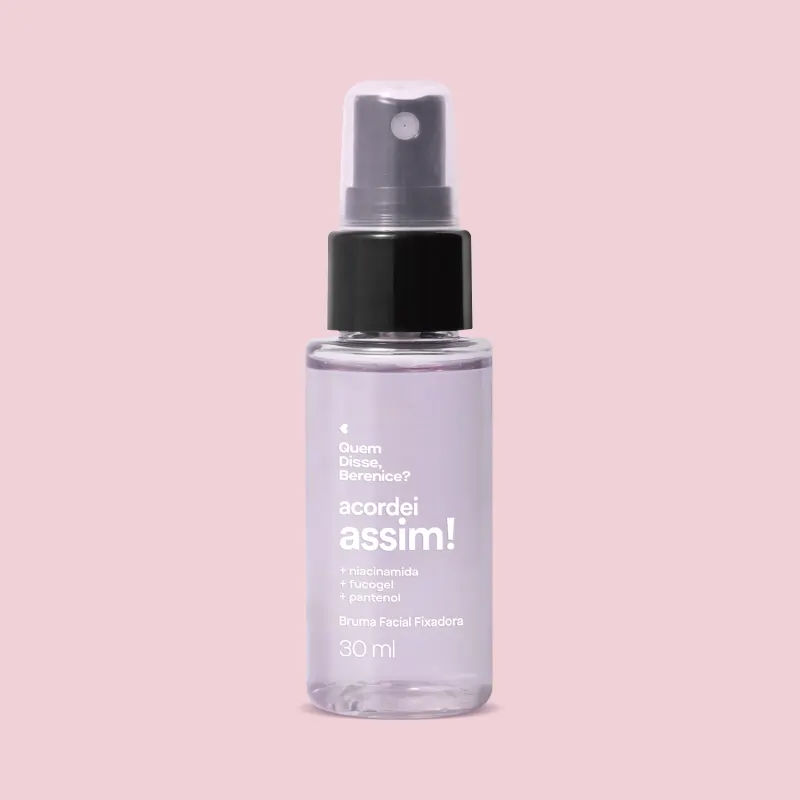 Frasco transparente com líquido azulado, válvula spray preta, tampa transparente e letras brancas contendo 30ml da bruma facial fixadora Acordei Assim Quem Disse, Berenice? em fundo lilás.