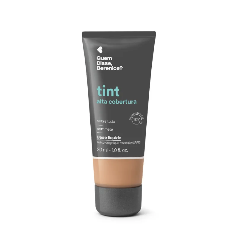 Bisnaga cinza escura com faixa bege de base líquida da marca Quem Disse, Berenice? com acabamento soft mate, com texto em destaque na cor azul indicando "tint alta cobertura".