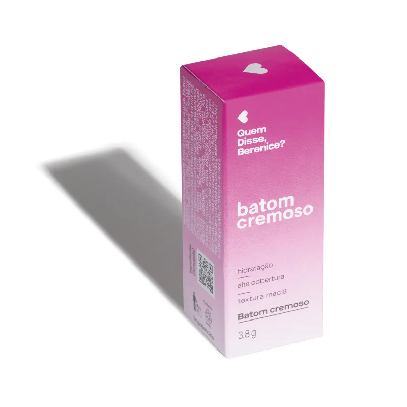 Caixa rosa com coração branco, contendo texto "Quem disse, Berenice?" e "Batom cremoso" em embalagem de 3,8g. A iluminação do ambiente forma uma longa sombra projetada atrás da embalagem.