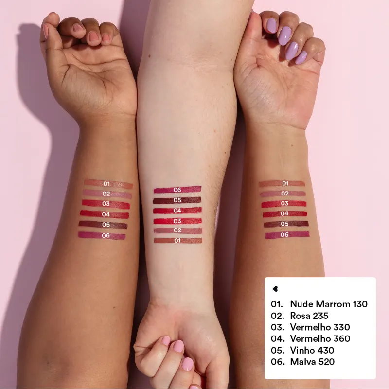 Imagem mostra três braços de cores diferentes estendidos sobre superfície branca sendo o braço mais a esquerda de pele negra, o do meio de pele branca e o da direita com pele parda, todos com diversos tons de batons aplicados sobre eles e seus códigos.