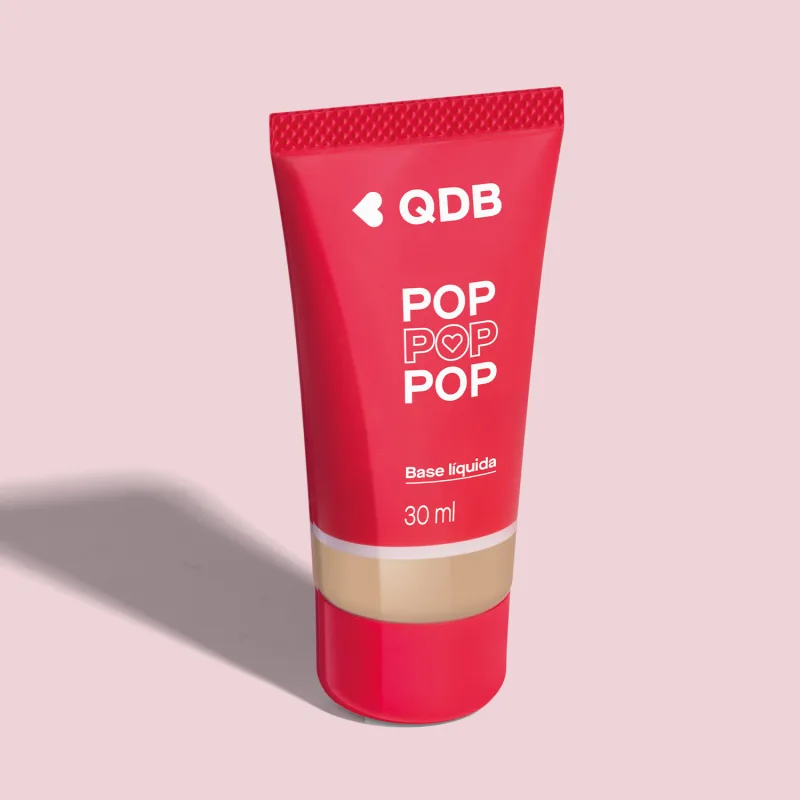 Imagem da base líquida soft matte da marca POP Quem Disse, Berenice? na cor 120N, em tubo rosa com parte transparente, mostrando a tonalidade do produto, e rótulo com letras brancas. O fundo da imagem é lilás com sombreado.